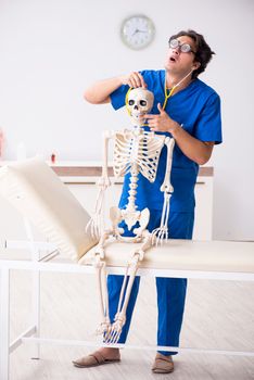 Funny doctor with skeleton in hospital