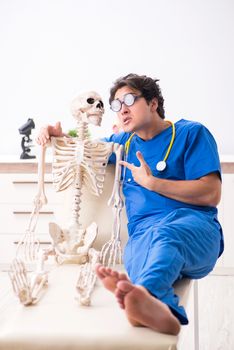 Funny doctor with skeleton in hospital
