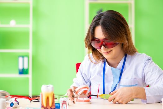 Woman dentist working on teeth implant