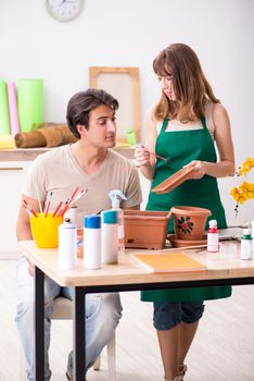 Couple decorating pots in workshop during class