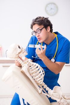 Funny doctor with skeleton in hospital