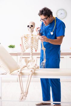 Funny doctor with skeleton in hospital