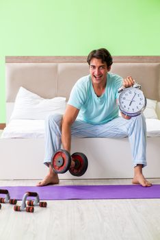 Young man in pajamas doing morning exercises 