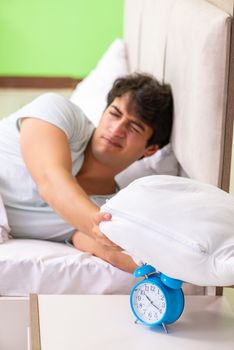 Young man having trouble waking up in early morning