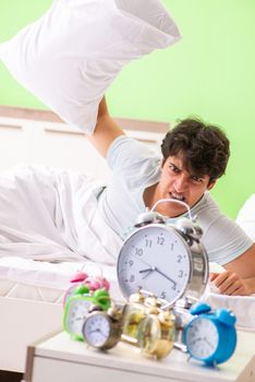 Young man having trouble waking up in early morning