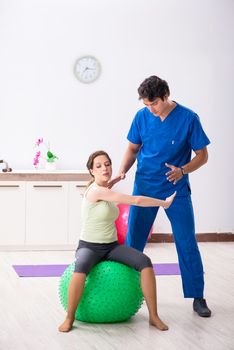 Fitness instructor helping sportsman during exercise