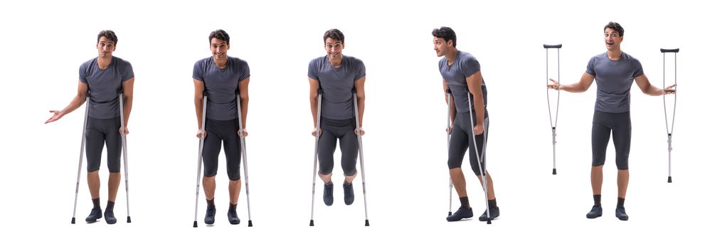 Young patient athlete sportsman suffering an injury trauma with crutches isolated on white