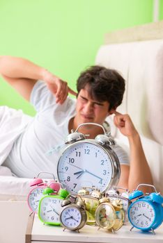 Young man having trouble waking up in early morning