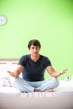 Young man in pajamas doing morning exercises 