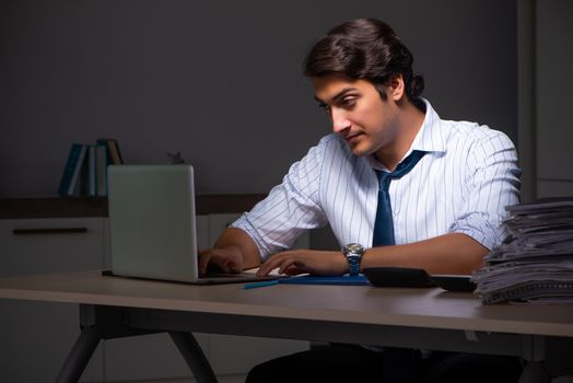 Young financial manager working late at night in office 