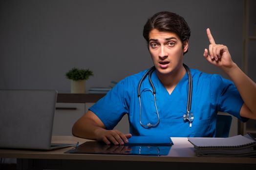 Young handsome doctor working night shift in hospital   