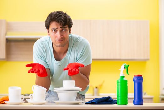 Young handsome man working in the kitchen 