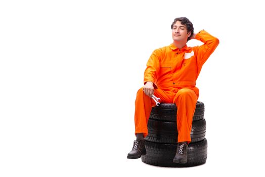 Young garage worker with tyre isolated on white