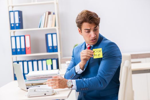 Office prank with kick me message on sticky note