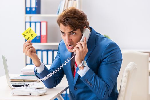 Office prank with kick me message on sticky note