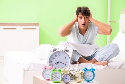 Young man having trouble waking up in early morning