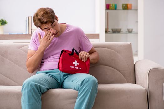 Sick man at home with first aid kit