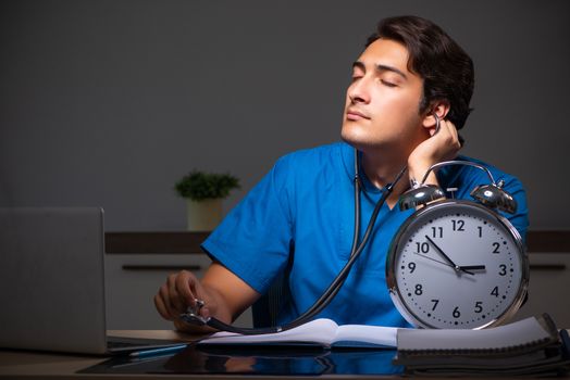 Young handsome doctor working night shift in hospital   