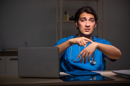 Young handsome doctor working night shift in hospital   