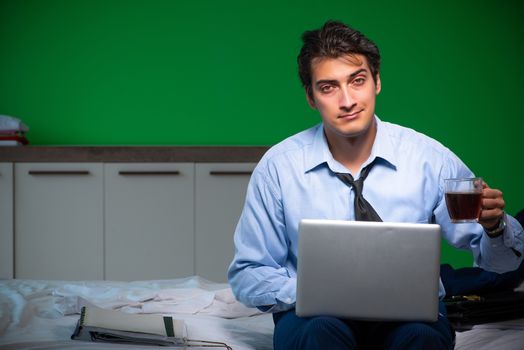Young businessman under stress in the bedroom at night 