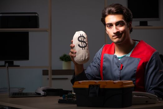 Young handsome repairman repairing computer 