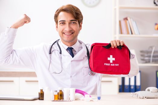 Young doctor with first aid kit in hospital