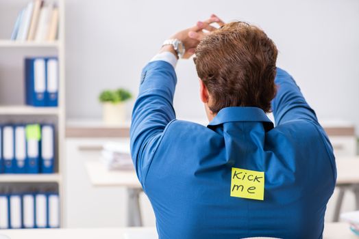 Office prank with kick me message on sticky note