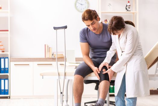 Young male patient visiting female doctor traumatologist 