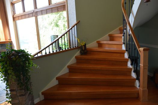 Wooden interior stairway of luxury residential house with railings