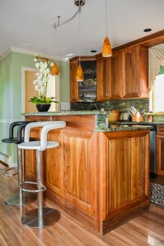 Stylish kitchen wooden interior with high chairs beside the island table
