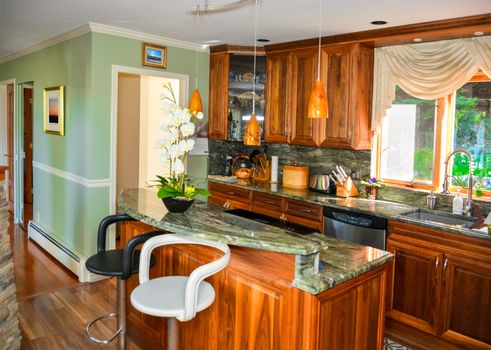 Stylish kitchen wooden interior with island table with two chairs beside