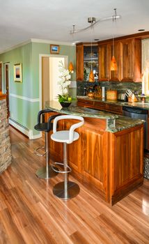 Stylish kitchen wooden interior with island table and two chairs in front