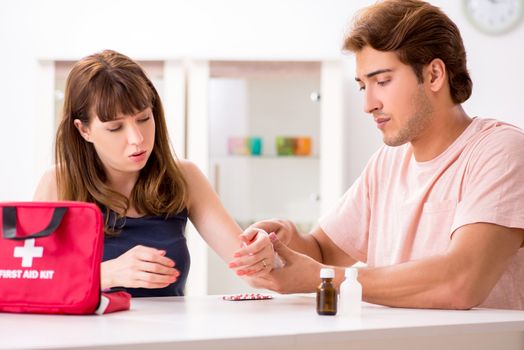 Young family getting treatment with first aid kit