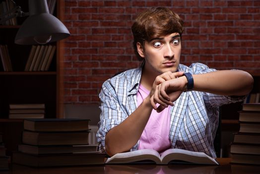 Young handsome student preparing for exams at night 