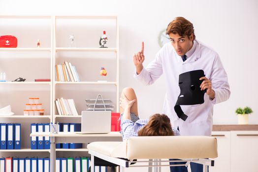 Young female patient visiting male doctor traumatologist 