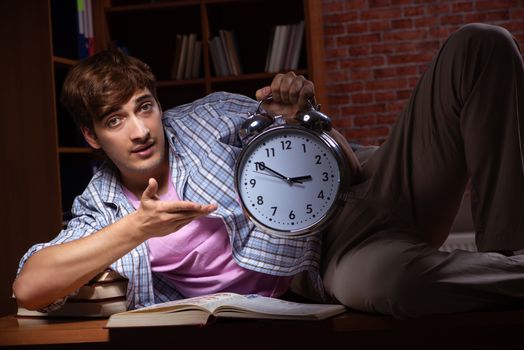 Young handsome student preparing for exams at night 