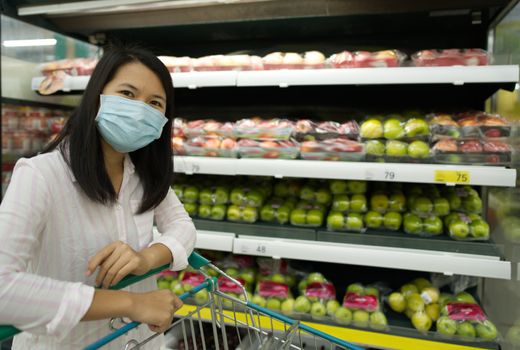 A woman shopping in a mall wearing a mask to prevent coronavirus select focus.