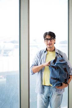 Young handsome student standing at the window 