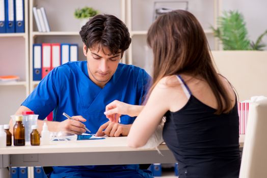 Young woman with bandaged arm visiting male doctor traumotologist 