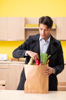 Young handsome man with vegetables in kitchen  