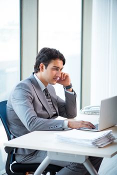 Young successful businessman working at the office 