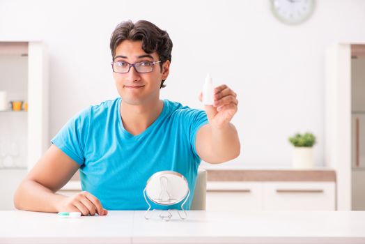 Man trying contact lenses at home