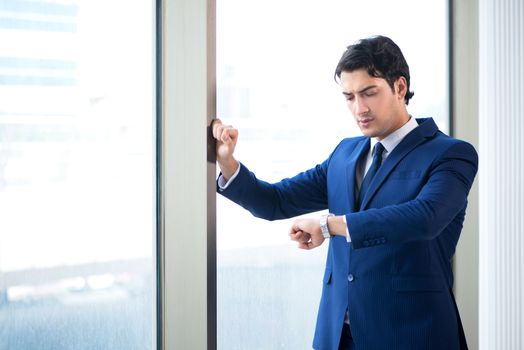 Young handsome businessman standing at the window 