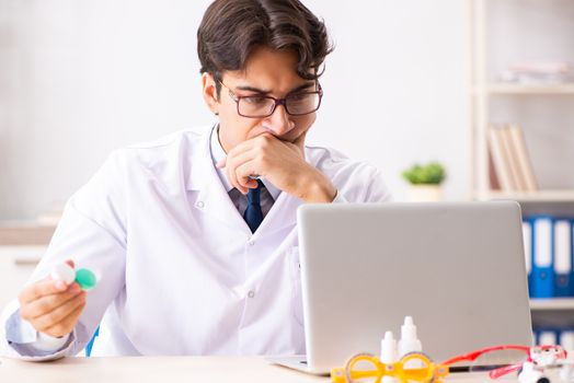 Young handsome doctor oculist working at the clinic 