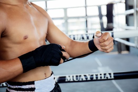 Boxer is swapping hands before punching with the boxing ring background.