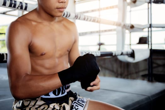 The boxer is swapping hands before punching against the boxing ring background.