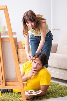 Young couple enjoying painting at home