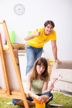 Young couple enjoying painting at home