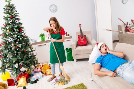 Young family cleaning apartment after christmas party