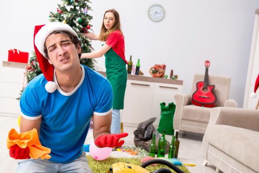 Young family cleaning apartment after christmas party